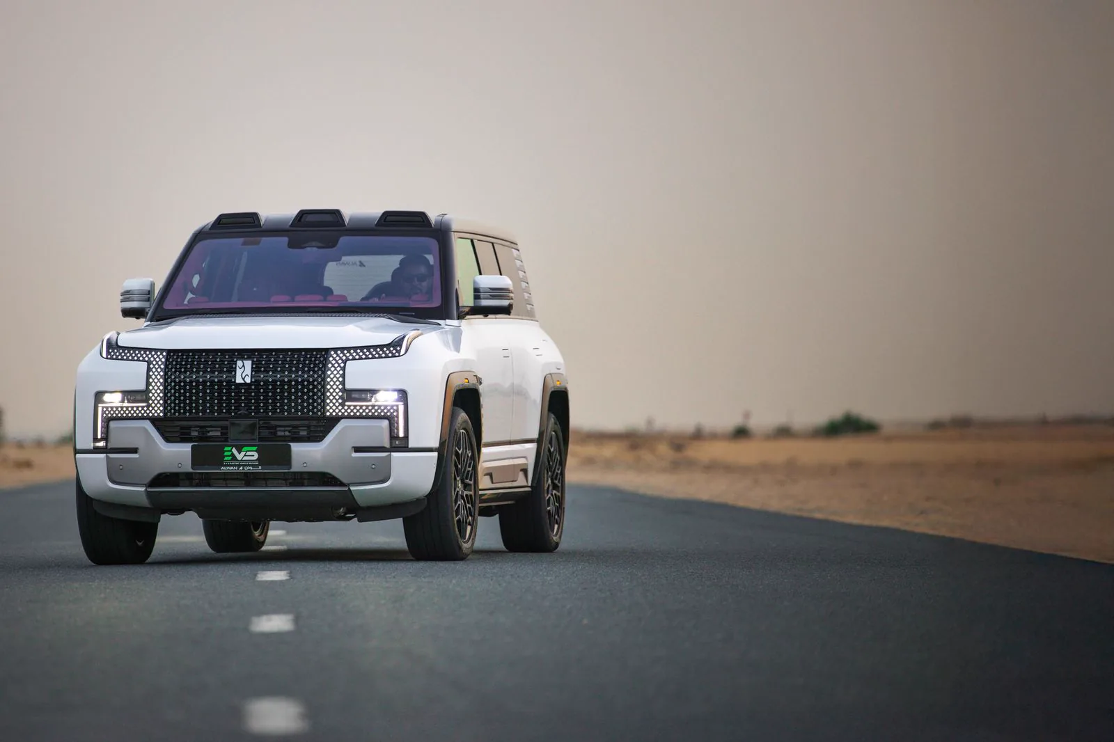 An electric SUV carrying EVS branding on an open road